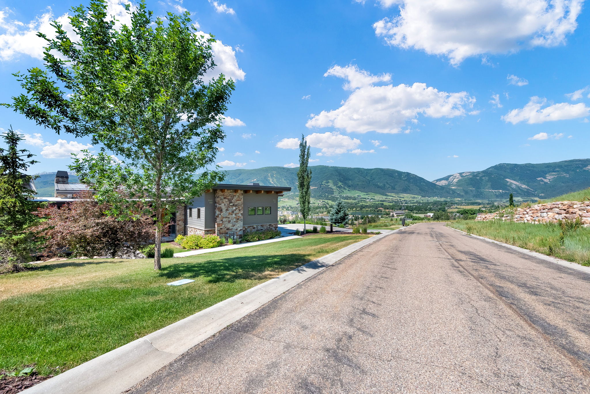 View of asphalt road with curbs and a mountain view
