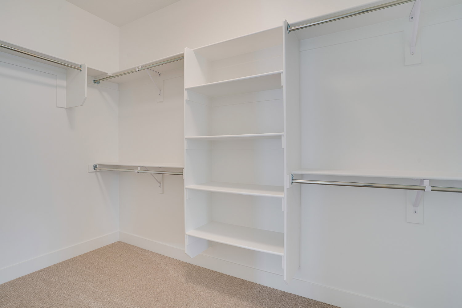Walk in closet with light colored carpet