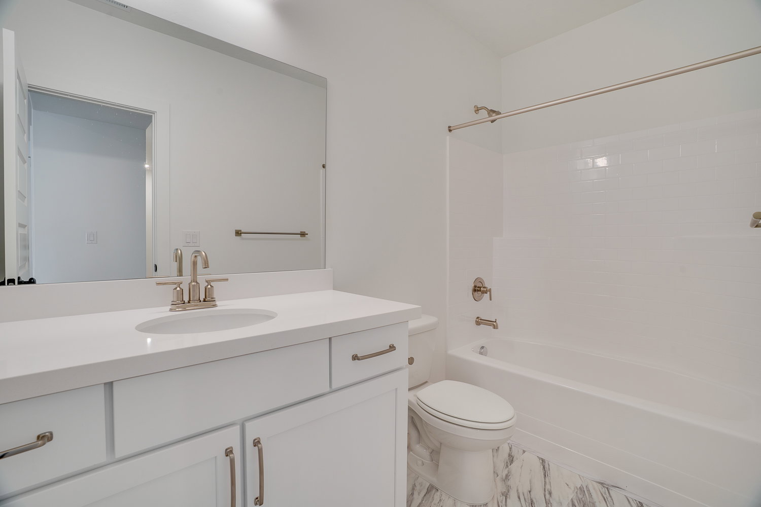 Bathroom featuring  shower combination, vanity, and light marble finish flooring