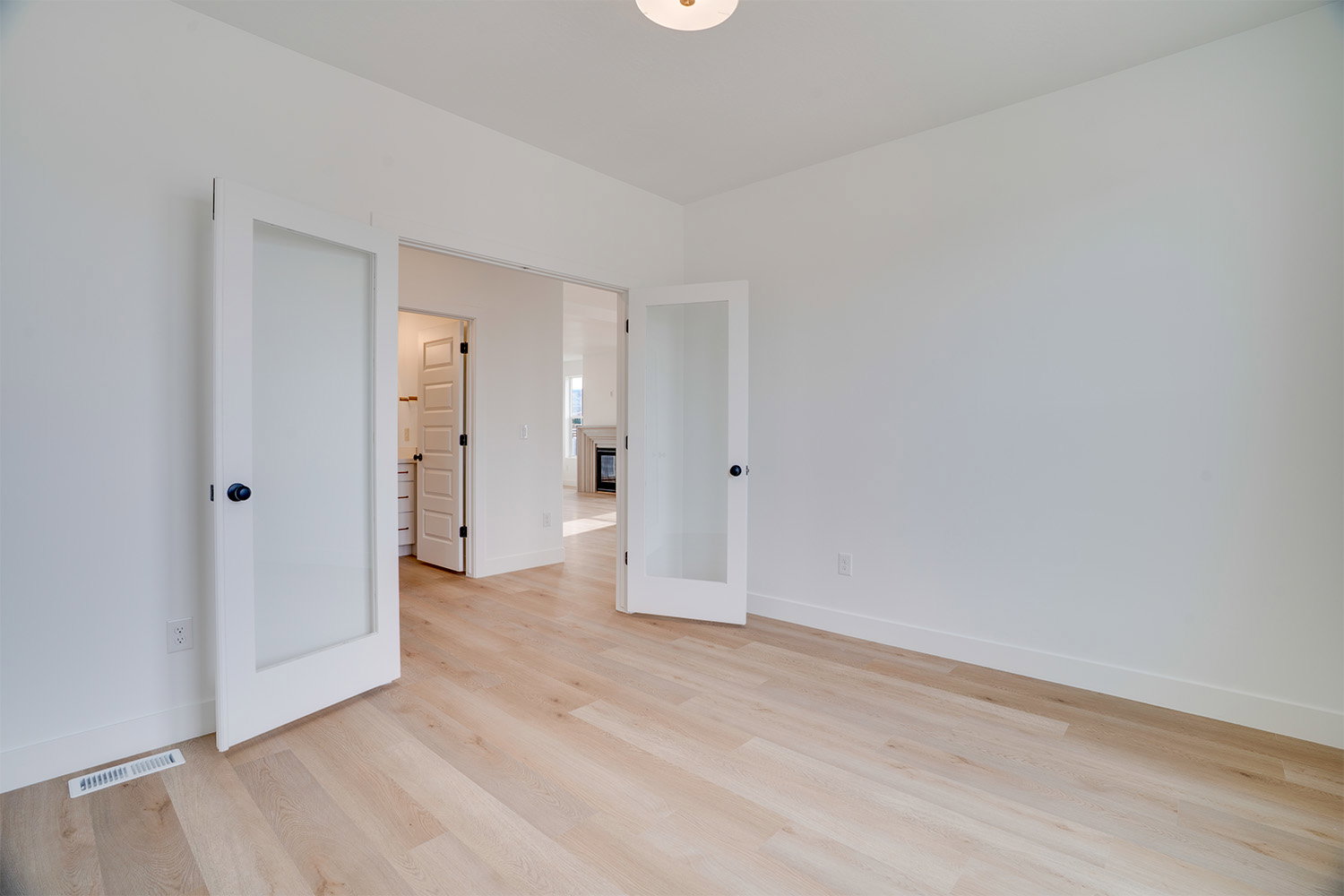 Unfurnished bedroom featuring light wood-style flooring and french doors