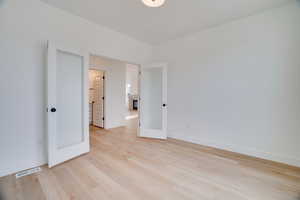 Unfurnished bedroom featuring light wood-style flooring and french doors