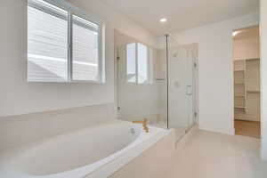 Bathroom featuring a bath, a shower stall, a walk in closet, light tile patterned floors, and recessed lighting