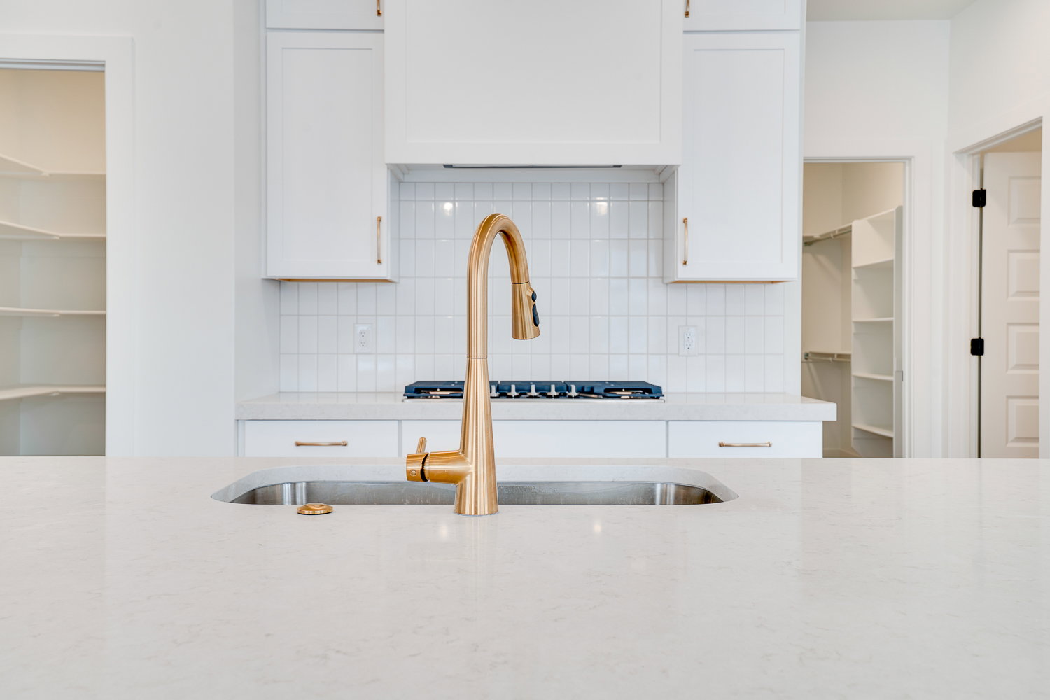 Kitchen featuring tasteful backsplash, white cabinetry, and light stone counters