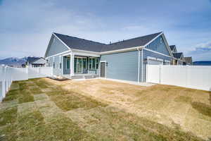 Back of house featuring a patio area, a fenced backyard, a shingled roof, and a garage