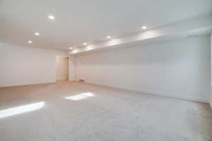 Finished basement with recessed lighting and light colored carpet