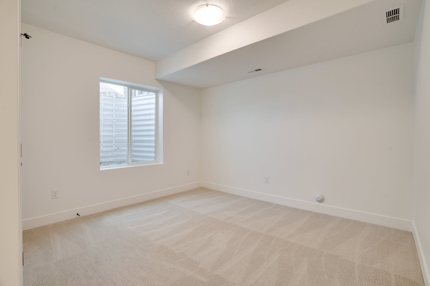 Spare room with light carpet and baseboards