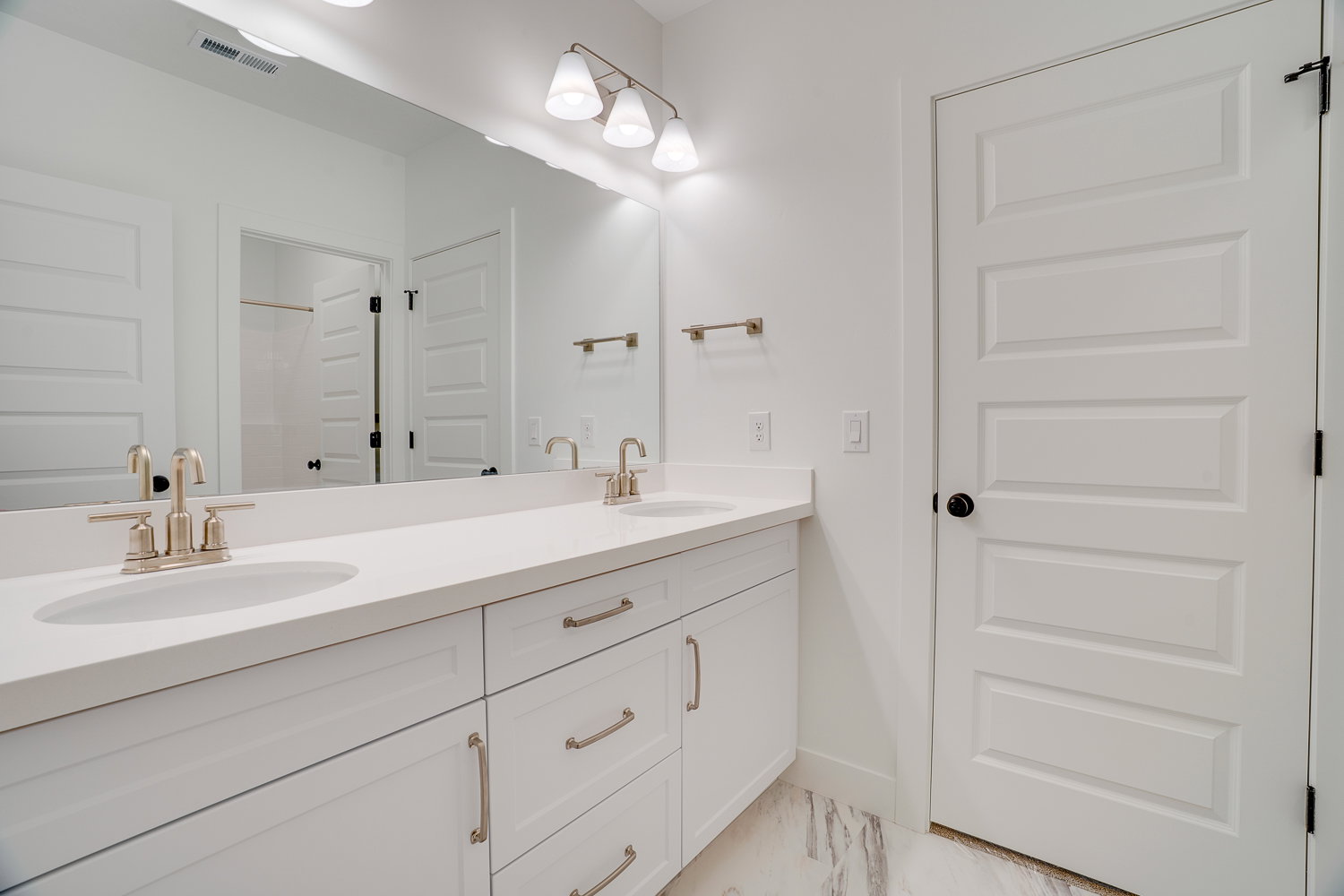Full bath with double vanity and light marble finish flooring