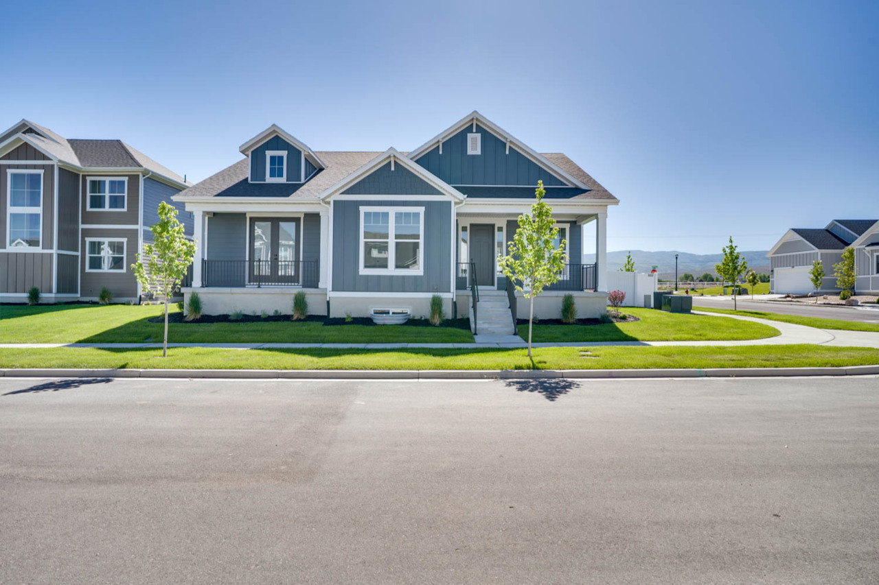 Single-story residence featuring a covered front porch with white columns, dark gray siding with white trim, and a prominent front-facing gable
