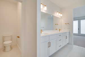 Bathroom with double vanity and light tile patterned floors