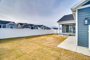Fenced backyard with a patio area and a residential view