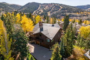 View from above of property featuring a mountain backdrop and a heavily wooded area