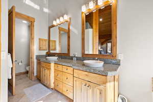 Full bathroom with double vanity and toilet