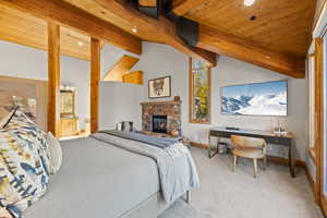 Bedroom featuring carpet, wood ceiling, a stone fireplace, ensuite bath, and recessed lighting