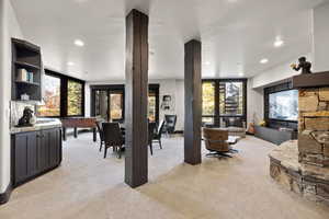 Living area featuring light carpet, a tile fireplace, recessed lighting, and healthy amount of natural light