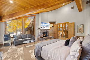 Bedroom featuring carpet floors, a wood ceiling with exposed beams, a fireplace, recessed lighting, and high vaulted ceiling