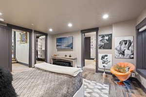 Bedroom featuring a walk in closet, recessed lighting, and wood finished floors
