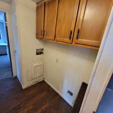 Laundry room featuring cabinet space, hookup for a washing machine, and dark wood-type flooring
