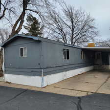 View of side of property featuring an attached carport and driveway