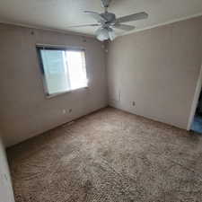 Spare room with a textured ceiling, carpet floors, and ceiling fan