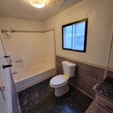 Full bathroom featuring a wainscoted wall, tile walls, a textured ceiling, bathing tub / shower combination, and vanity