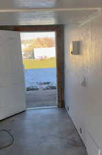 Doorway to outside with unfinished concrete flooring