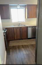 Kitchen featuring light countertops, stainless steel appliances, and dark wood-type flooring