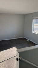 Carpeted empty room featuring baseboards