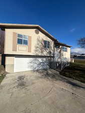 View of property exterior with driveway and an attached garage
