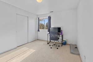Office with baseboards and light colored carpet