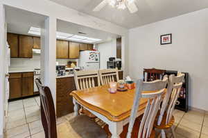 Dining room with light tile patterned floors and a ceiling fan