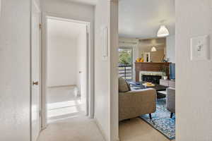 Hall featuring a textured wall and light carpet