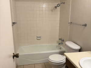 Bathroom with vanity, light tile patterned floors, and shower / bathtub combination