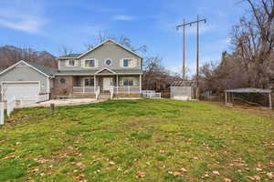 Traditional-style home featuring covered porch, an outbuilding, and a garage