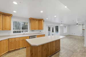 Kitchen featuring a center island, light countertops, light wood-type flooring, open floor plan, and recessed lighting