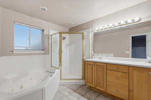 Full bath with double vanity, a jetted tub, and a shower stall