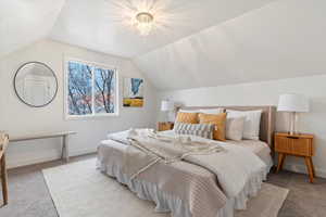 Bedroom featuring carpet flooring and lofted ceiling