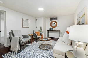 Living area with dark wood-style flooring and recessed lighting