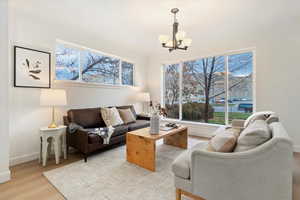 Living room featuring wood finished floors, crown molding, and a chandelier