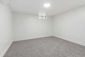 Basement featuring light carpet and baseboards