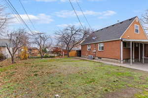 Back of house with a patio area, brick siding, and a shingled roof