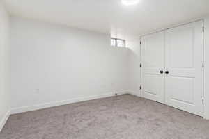Unfurnished bedroom featuring carpet flooring and a closet
