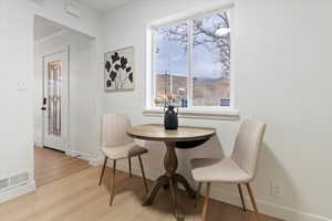 Dining room featuring light wood-style floors and ornamental molding
