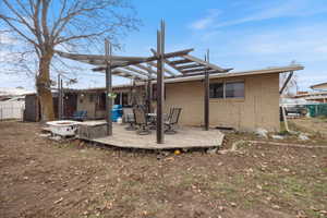 Back of house featuring an outdoor fire pit, a deck, brick siding, and outdoor dining area