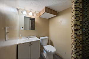 Bathroom featuring vanity, a shower with curtain, a textured ceiling, and wood finished floors