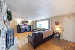 Living area with a textured ceiling and wood-type flooring