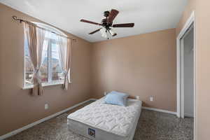 Carpeted bedroom featuring baseboards and a ceiling fan