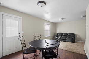 Dining room featuring dark wood-style floors and a textured ceiling