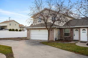 Traditional-style home with brick siding, concrete driveway, and roof with shingles