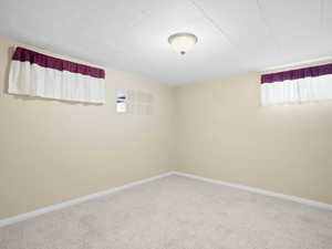 Carpeted empty room featuring baseboards