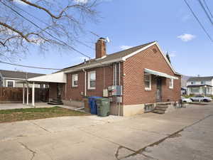 Back of house featuring entry steps, brick siding, and a chimney